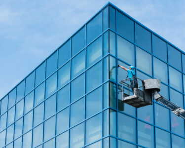 Washer washing the windows of modern skyscraper